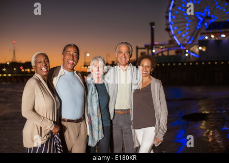 Portrait of senior friends on beach at night Banque D'Images