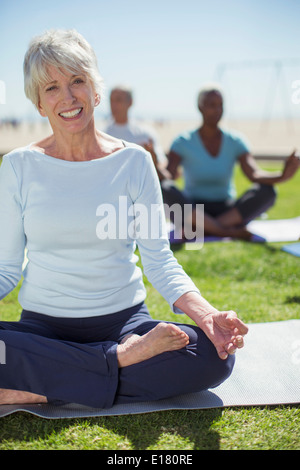 Portrait of smiling senior woman practicing yoga in park Banque D'Images