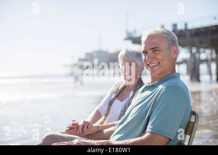 Portrait of senior couple relaxing on sunny beach Banque D'Images