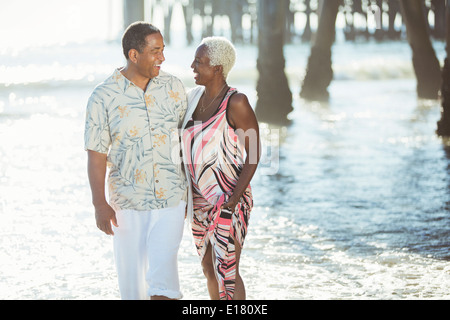 Senior couple walking on sunny beach Banque D'Images