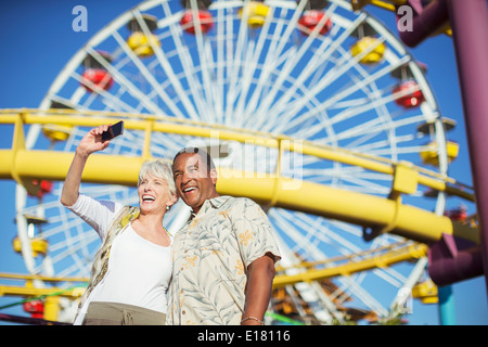 Young couple enthousiaste à selfies amusement park Banque D'Images