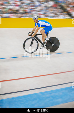 Track cyclist riding in velodrome Banque D'Images