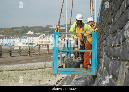 La réparation de mur après les tempêtes de 2014 promenade Aberystwyth Banque D'Images