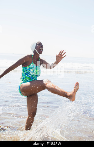 Woman splashing in ocean surf Banque D'Images