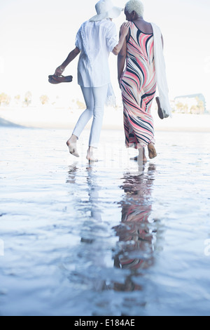 Les femmes marchant pieds nus sur la plage Banque D'Images