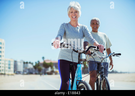 Portrait of senior couple with bicycles sur beach boardwalk Banque D'Images