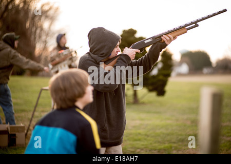 Jeune homme tenant un fusil, vise un disque d'argile à Bel Air, Maryland, USA Banque D'Images