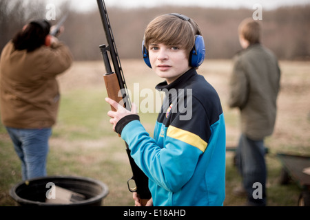 Jeune homme tenant un fusil, le port de protection auditive à Bel Air, Maryland, USA Banque D'Images