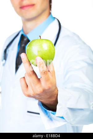 Main du médecin tenant une pomme verte fraîche gros plan sur fond blanc Banque D'Images