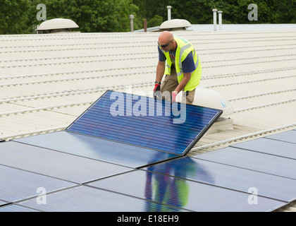 Les panneaux solaires photovoltaïques en cours d'installation sur un toit Banque D'Images