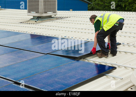 Les panneaux solaires photovoltaïques en cours d'installation sur un toit Banque D'Images