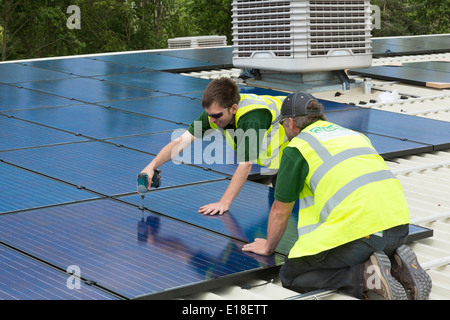 Les panneaux solaires photovoltaïques en cours d'installation sur un toit Banque D'Images