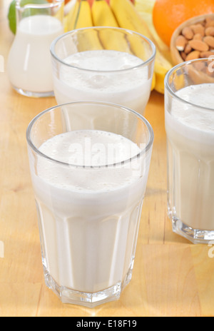 La banane et le lait d'amande smoothie dans un verre sur une table de cuisine. Boisson d'été fait de la banane, le lait d'amande et quelques dactyl. Banque D'Images