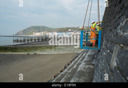 La réparation de mur après les tempêtes de 2014 promenade Aberystwyth Banque D'Images