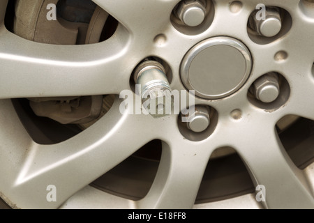 Photo horizontale gros plan de verrouillage à clé d'écrou de roue sur jante de roue de voiture Banque D'Images