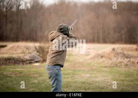 Jeune homme tenant un fusil, vise un disque d'argile à Bel Air, Maryland, USA Banque D'Images