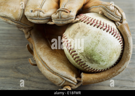 Sale vieille photo horizontale Gros plan intérieur de baseball gant très utilisé sur bois rustique Banque D'Images