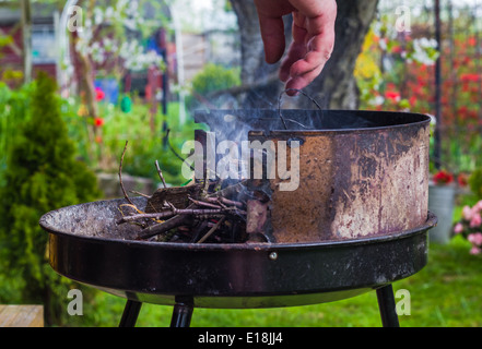 Allumer le feu au printemps barbecue dans le jardin Banque D'Images