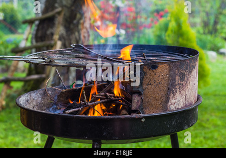 Allumer le feu au printemps barbecue dans le jardin Banque D'Images