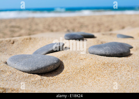 Libre de quelques pierres plates gris sur le sable d'une plage Banque D'Images