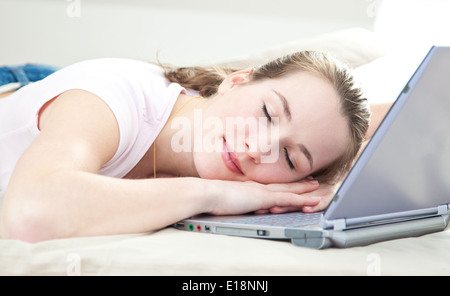 Jolie jeune femme endormie sur son ordinateur portable Banque D'Images
