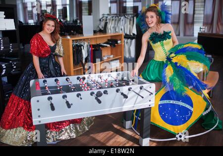 Luebeck, Allemagne. 26 mai, 2014. Annika modèles Silkeit (R), portant une robe de bal, avec les couleurs nationales du Brésil et de la KOC Felic (L), portant une robe de bal le sport national allemand couleurs, jouer autour de baby-foot à Luebeck, Allemagne, 26 mai 2014. Créateur de mode à base de Luebeck Manuela Offenborn conçu les robes de bal pour la prochaine Coupe du monde de football 2014 au Brésil. Photo : Jens Buettner/dpa/Alamy Live News Banque D'Images