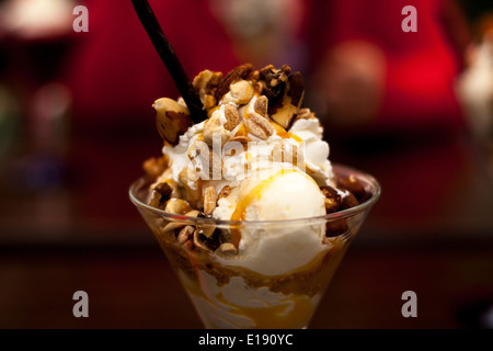 Délicieuse glace à la vanille recouverte de caramel et noix diverses. Banque D'Images