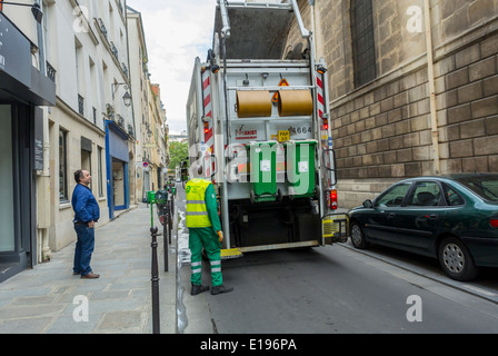 Paris, France, quartier du Marais, scène de rue, recyclage de verre Français camion poubelle hommes, ramasser Wheely bin sur le trottoir Banque D'Images