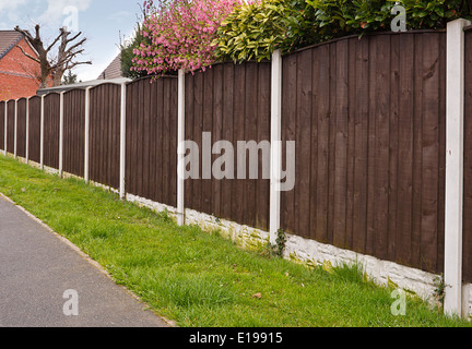 Panneaux de clôtures conseil fermer avec des poteaux en béton récemment repeint avec de la créosote Banque D'Images