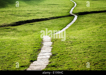 Un long sentier dallé qui serpente à travers les champs dans les vallées du Yorkshire, England, UK. Banque D'Images