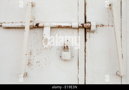 Fragment de porte en métal blanc avec cadenas anciens Banque D'Images