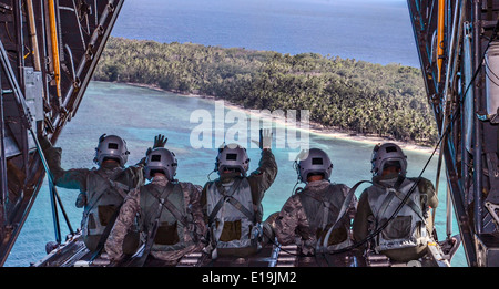 L'équipage de l'US Air Force avec le 36e Escadron de transport aérien, vague à l'arrière d'un C-130 Hercules pour les gens de l'ouest du Pacifique et les îles de la Micronésie participant à l'Opération Goutte de Noël 10 Décembre, 2013. Chaque année en décembre American C-130 Hercules par hélicoptère de la nourriture, des fournitures et des jouets pour les insulaires dans toute la Micronésie. Banque D'Images