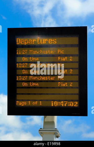 Train électronique conseil départs contre un ciel bleu England UK Banque D'Images