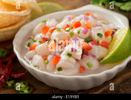 Un ceviche de pétoncles frais avec oignon rouge, coriandre, piment rouge, citron vert et piment serrano. Banque D'Images