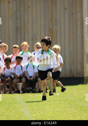 Jeune garçon en compétition dans l'exécution de course sur sportsday Banque D'Images