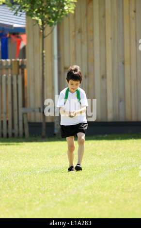 Jeune garçon en concurrence dans l'oeuf et la cuillère sur course sportsday Banque D'Images