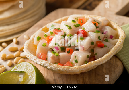 Un ceviche de poisson blanc frais à la tomate, oignon rouge, coriandre, piment rouge, citron vert et piment serrano. Banque D'Images