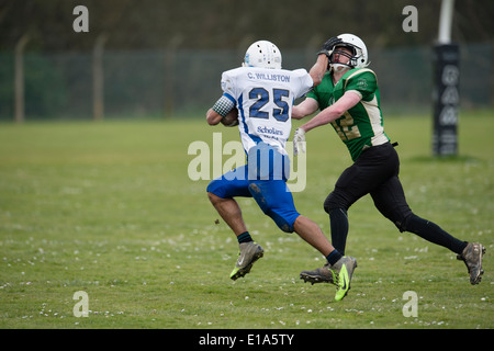 Dans l'éducation Sport UK : Tarannau, Université d'Aberystwyth football américain (en blanc) de la lecture d'un match de ligue Pays de Galles UK - un coureur avec le ballon repousse un plaqueur potentiel Banque D'Images