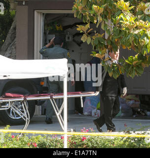 Mission Viejo, en Californie, USA. 26 mai, 2013. Un adjoint du shérif du comté d'Orange a l'air dans le garage d'une maison sur le bloc de 25600 Pacific Hills Drive mardi après-midi en tant que travailleurs de l'enquête se déplacer dans avec des civières de ramasser les corps de 4 personnes non encore identifiés dans la maison. Plusieurs armes que l'on pouvait voir sur l'écran le long d'un mur de garage ---a répondu à un appel au 911 pour un chèque d'aide sociale dans le bloc 25600 de Pacific Hills Drive à Mission Viejo mardi matin. Adjoints du shérif du comté d'Orange est arrivé de trouver 2 personne décédée mâles et deux femelles décédé dans un deux stor Banque D'Images