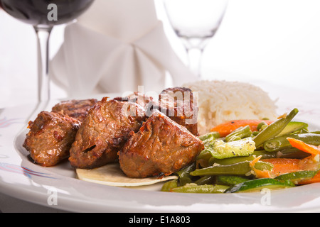 Plan Macro sur shish kebabs garni de légumes et riz pilaf, serviette et verre de vigne sur l'arrière-plan Banque D'Images