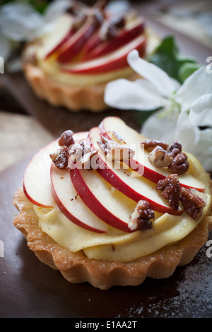 Tartelettes avec des tranches de pomme, de crème et de remplissage de pécan Banque D'Images