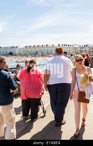 Les gens qui marchent le long d'un quai, sur chaude journée ensoleillée. Llandudno North Wales, Grande Bretagne. Banque D'Images