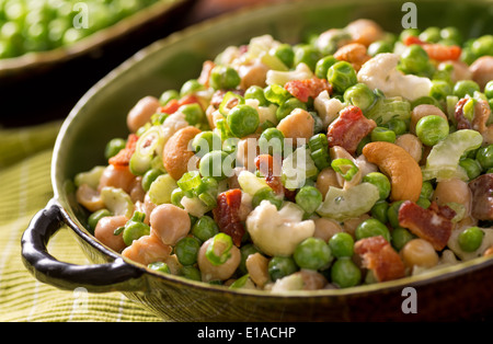 Un bol de salade de pois frais avec les petits pois, les pois chiches, les noix de cajou, oignon vert, le lard, le céleri, et crémeuse sauce ranch. Banque D'Images