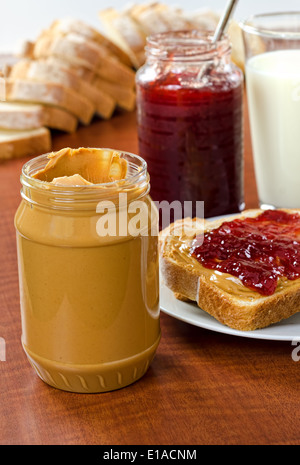 Le beurre d'arachide et confiture avec du pain et un verre de lait. Banque D'Images