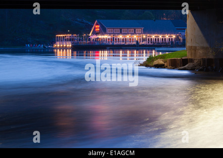 Une tortue Jacks restaurant sur la rive du lac Muskoka à la tombée de la nuit avec des lumières se reflétant dans l'eau. Port Carling Ontario, Canada Banque D'Images