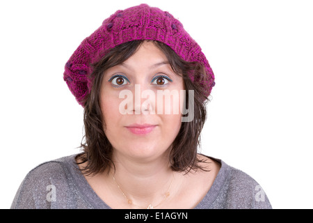 Jolie femme portant un chapeau d'hiver tricoté violet d'ouvrir grands les yeux dans l'étonnement et le scepticisme pour montrer son incrédulité, Banque D'Images