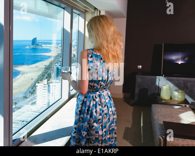 Vue arrière d'une femme regardant par la fenêtre, l'Art Hotel, Barcelone, Catalogne, Espagne Banque D'Images