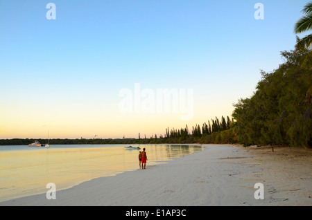 L'homme et le garçon debout sur une plage tropicale vide en début de soirée, juste avant le coucher du soleil. Banque D'Images