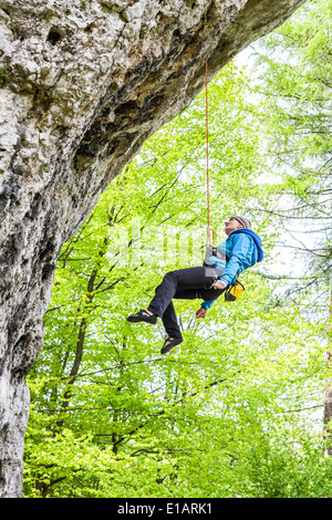 Female climber, woman climbing rock, descente en rappel depuis le haut. Banque D'Images