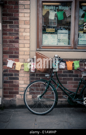 Vélo féminin traditionnel avec panier en osier, appuyé contre un bâtiment à Thirsk. Banque D'Images